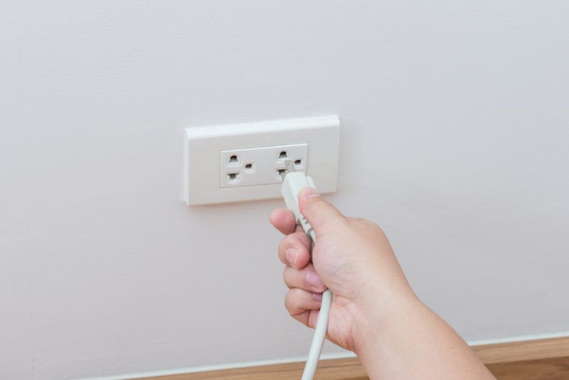 plug-unplugging-socket-wall-outlet
